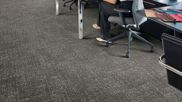 Interface Step in Time carpet tile shown with office cubicles and brick walls